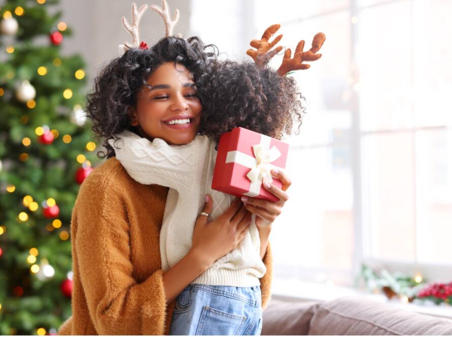 A person hugging a child with a gift, Embrace the Joy: 12 Dental Tips for a Twinkling Holiday Smile